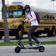 Load image into Gallery viewer, Man in helmet riding the Mantis 40 MPH electric scooter
