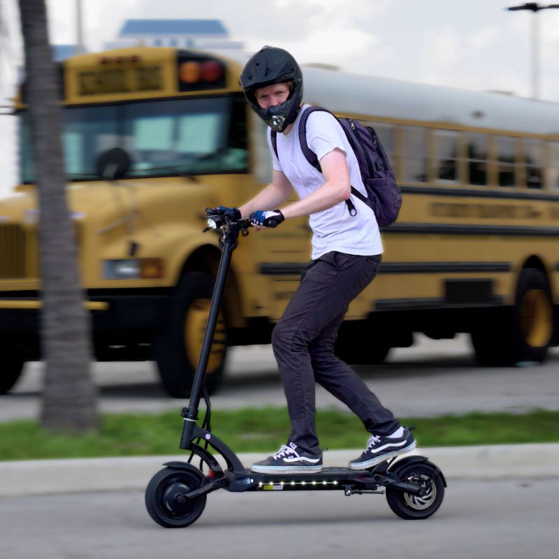 Man in helmet riding the Mantis 40 MPH electric scooter